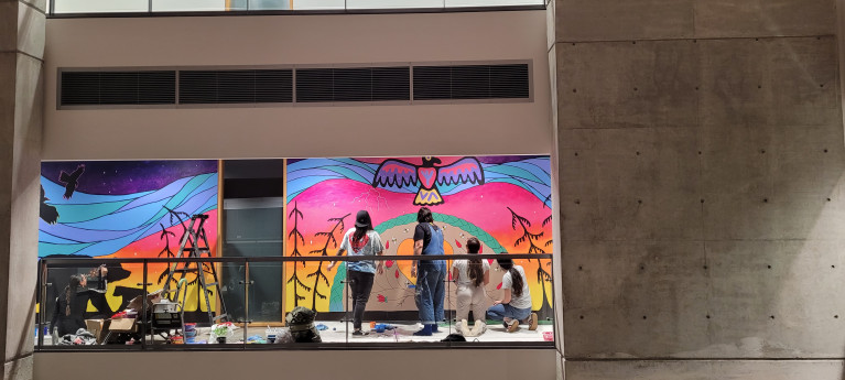 Students painting the mural on the wall in Kina Wiiya Enadong Building at UTSC