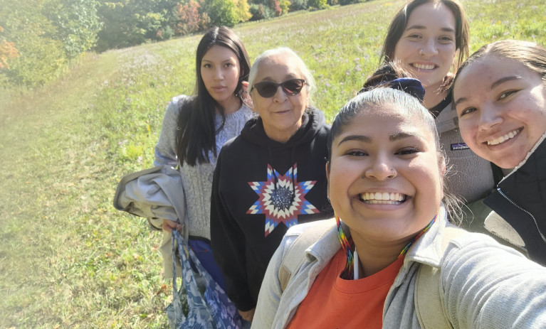 Students taking a selfie picture with an Indigenous Elder after an educational workshop